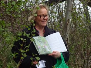 Catharina med boka slått opp på gjerdevikke